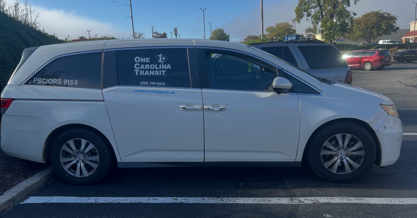 One Carolina Transit minivan with the company logo on the rear side window